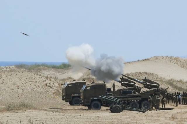 Philippine army personnel fire their Autonomous Truck Mounted howitzer system (ATMOS) during this week’s Balikatan drills [Ted Aljibe/AFP]