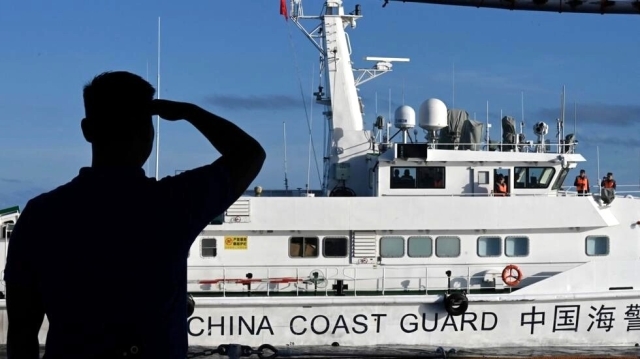 This file photo shows a man looking at a China Coast Guard vessel during a Philippine Coast Guard mission to deliver provisions at Second Thomas Shoal in the South China Sea on November 10, 2023. © Jam Sta Rosa, AFP 
