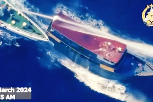 The Philippine military released a video clip showing a white ship marked China Coast Guard crossing the bow of a grey vessel it identified as the Philippine supply boat Unaizah May 4, and unleashing its water cannon.