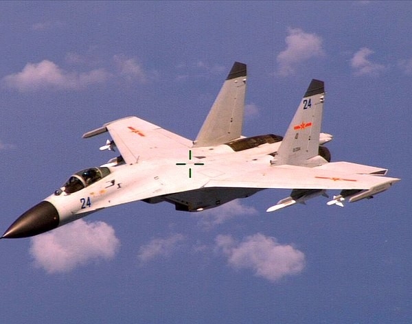 An armed Chinese Shenyang J-11 fighter jet flies near a U.S. Navy Boeing P-8A Poseidon patrol aircraft over the South China Sea about 220 km east of Hainan Island in international airspace 