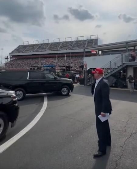 Trump, seen here globbing on to a NASCAR crowd to pretend they were there for him, waves to any moving red object he sees in his bizarro, increasingly desperate campaign. 