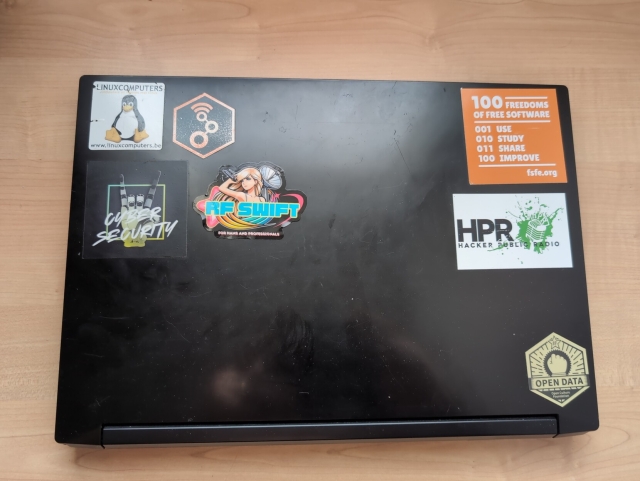 laptop cover showing stickers on different projects from Linux, gnuradio, HPR hacker public radio, open data and RF swift