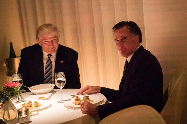 A famous photo of Mitt Romney having dinner with Donald Trump shortly after Trump won the 2016 election. Trump has a massive grin on his face. Romney looks embarrassed that a photographer caught them together.