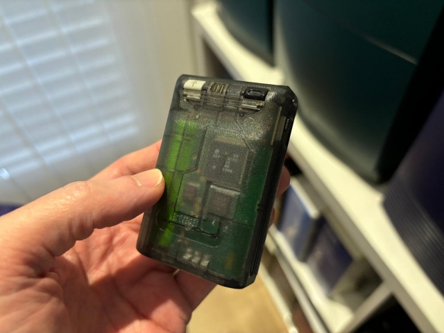 hand holding motorola pager with semi transparent case. you can see PCB and chips