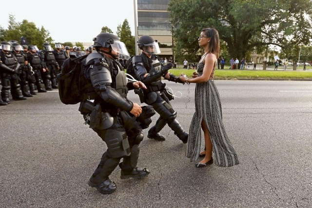 Taking a Stand in Baton Rouge is a photograph of Ieshia Evans, a nurse from Pennsylvania, being arrested by police officers dressed in riot gear during a protest in Baton Rouge, Louisiana, on 9 July 2016. The protest began in the aftermath of the shooting by police of Alton Sterling and Philando Castile. The image, taken by Jonathan Bachman for Reuters, became a viral phenomenon on social media, described by several media organizations as "iconic", with some comparing the image (and Evans) to well-known images of other lone protesters, such as the photograph of "Tank Man" in the Tiananmen Square protests of 1989. 