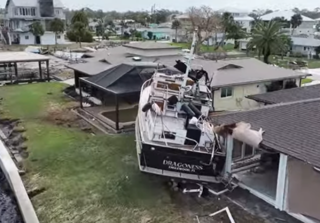 Boat that has drifted into someone's house and is now out of the water