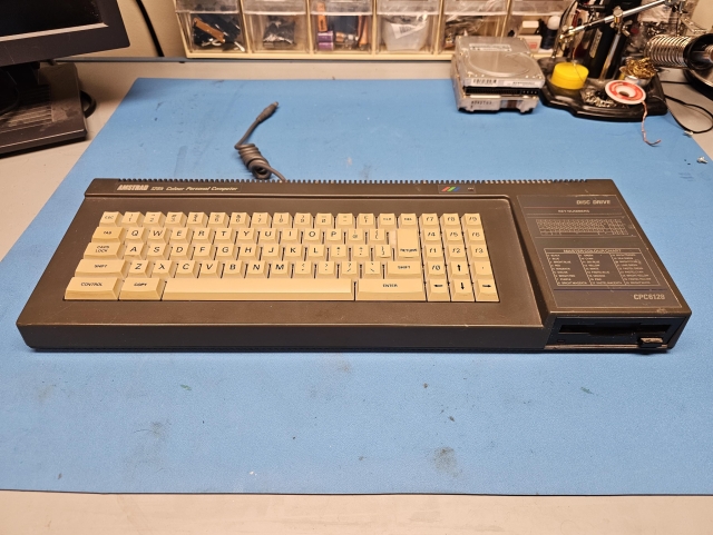 Amstrad CPC 6128 sitting on a workbench. 