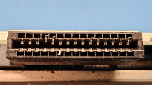 Cartridge port on an Atari 65XE computer with the motherboard removed from its case for a clearer view. There are several bent pins.