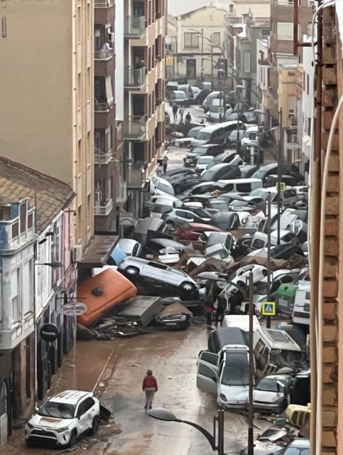 Photo of a street in Catarroja in Valencia with cars piled high between houses, after yesterday’s torrential rains. 