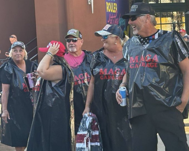 Trump idiots wearing garbage bags imprinted with "MAGA Garbage" on the front.