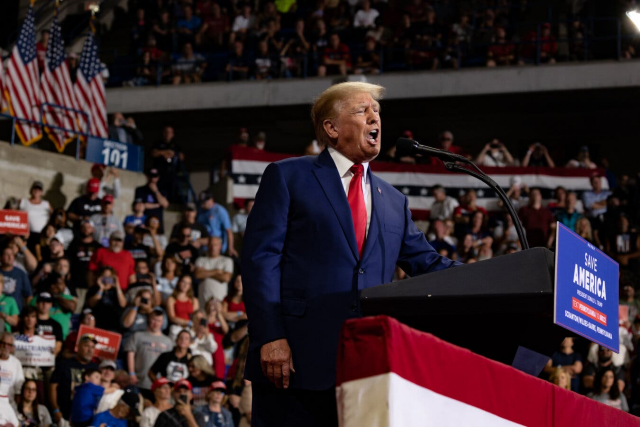 Donald Trump holding a speech at a campaign rally.