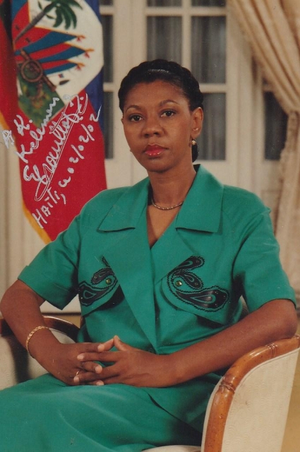 Photo of Ertha Pascal-Trouillot in front of Haiti's flag. She is a Black woman with black hair.